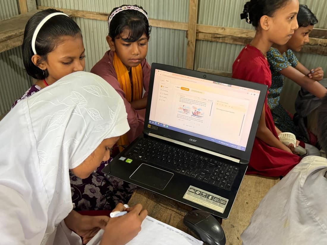 Students sharing a laptop in a coastal classroom